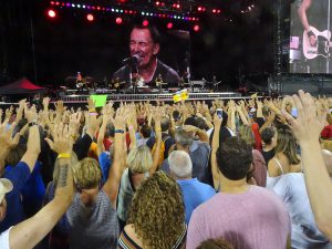 Photo of crowd near stage watching Bruce Springsteen perform.