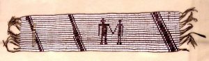 photograph of a woven wampum belt. the belt itself is a tan color with darker diagonal lines a a depiction of two human silhouettes holding hands