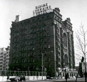 A black and white photograph of the Divine Lorraine Hotel. The building is ten stories tall. A sign on top of the building announces the hotel's name.