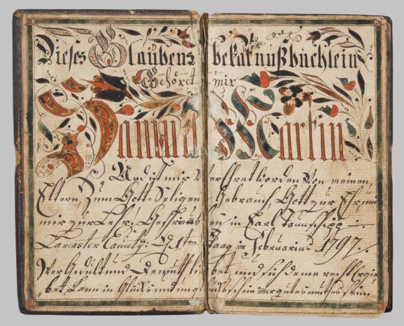 A color photograph of a booklet from 1790. The pages are yellowed with age but the calligraphy is still visible. The title is handwritten in shades of orange and green, and the subsequent text is detailed in cursive.