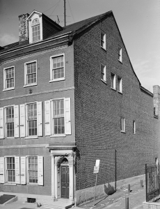 This black and white photograph shows a three story house on Locust Street in Philadelphia. It is made of brick and has eight windows on the front as well as seven on the side.