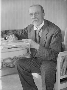 This black and white photograph depicts Tomáš Garrigue Masaryk, an independence leader for Czechoslovakia. He is wearing a plaid suit and sitting at a table.