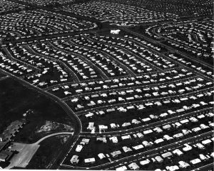 This aerial black and white photograph shows several hundred houses aligned in straight rows in Levittown, Pennsylvania.