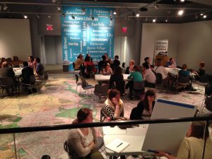 Photograph of event on floor covered by a map of Philadelphia.