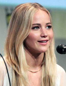 This color photograph shows Jennifer Lawrence answering a question at a media event.