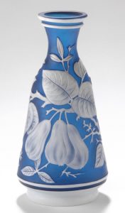 Photograph of blue glass vase decorated with white fruits and flowers