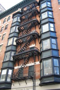 Color photograph showing a fire escape decorated with ornate metalwork.