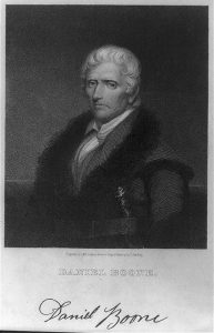 A black and white illustration of Daniel Boone wearing a coat with fur on the collar and lapels. He has an elaborate hunting knife tucked into his belt.