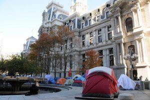 Color photograph depicting many tents pitched outside of Philadelphia City Hall.