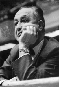 Black and white photograph depicting Eddie Gottlieb from chest up. He is leaning his head in his hand.
