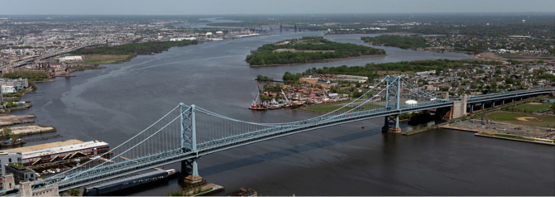 A color photograph of the Benjamin Franklin Bridge connecting Philadelphia to Camden over the Delaware River.
