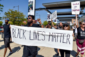 Demonstrators carrying a banner for Black Lives Matter.