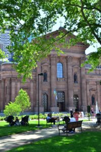 People relaxing outside the Cathedral Basilica of Saints Peter and Paul on a summer day.